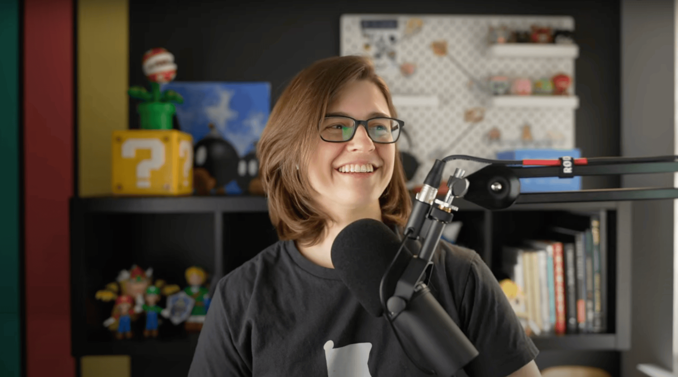 Screen shot of Lindsay Miller sitting in front of a microphone for a video podcast session.