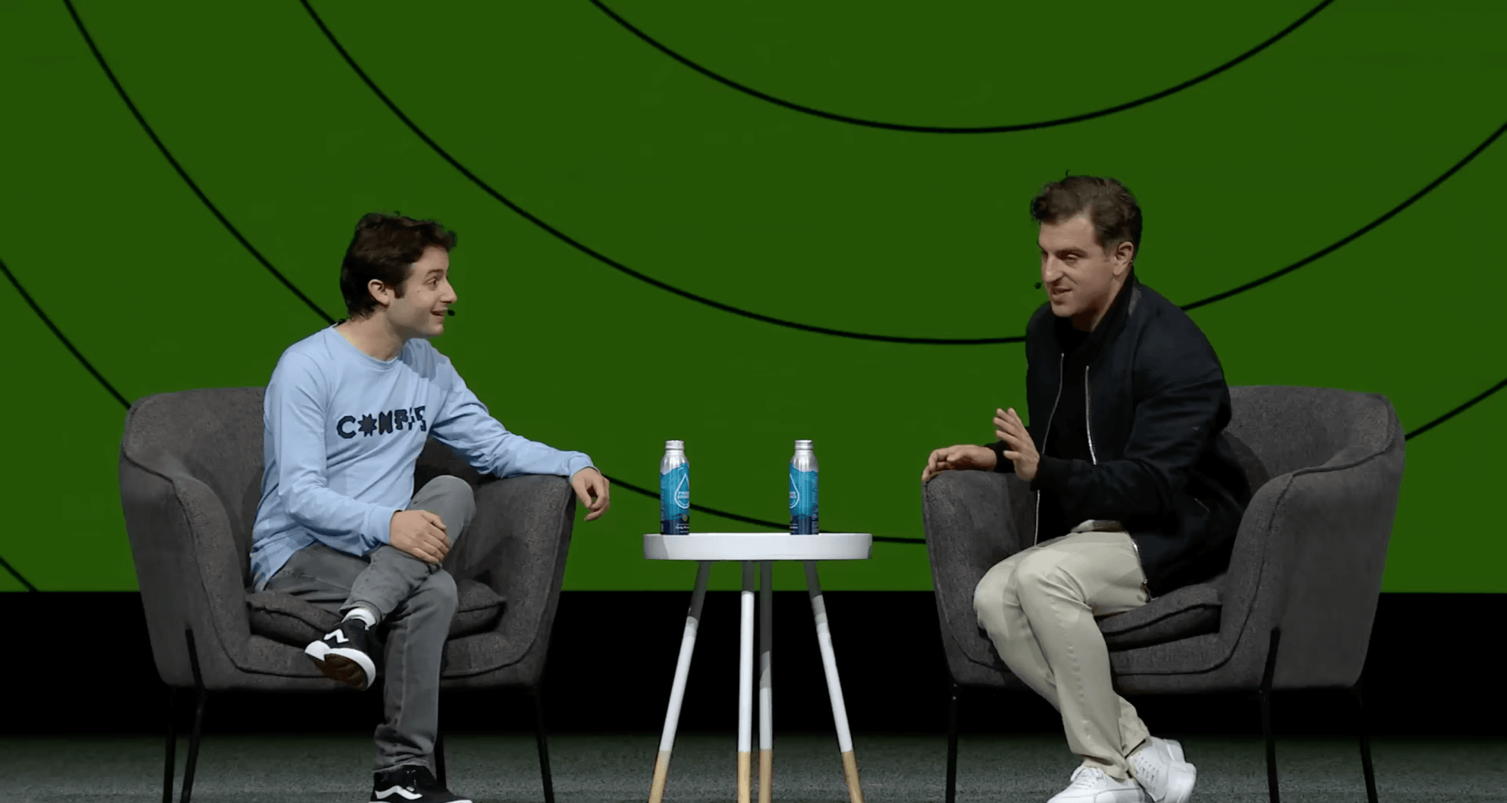 Dylan Field and Brian Chesky sitting in facing chairs and chatting on stage